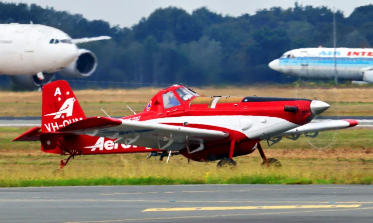 A red and white AT-802F firefighting aircraft sits on an Austrian tarmac ready for takeoff